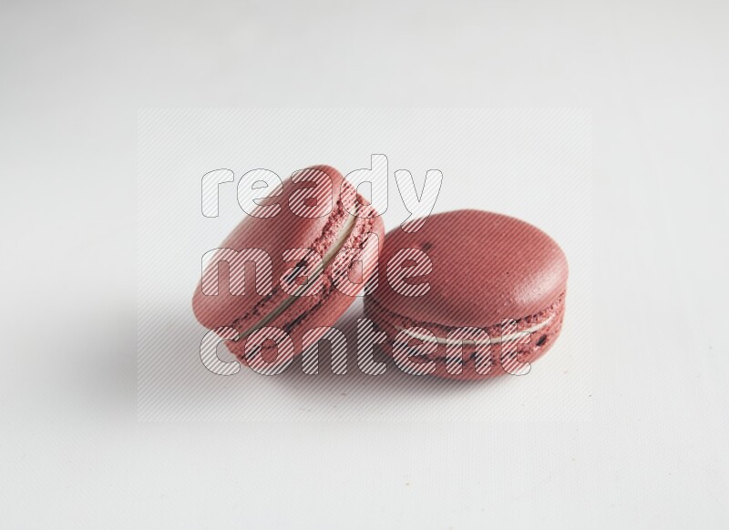 45º Shot of two Red Velvet macarons on white background