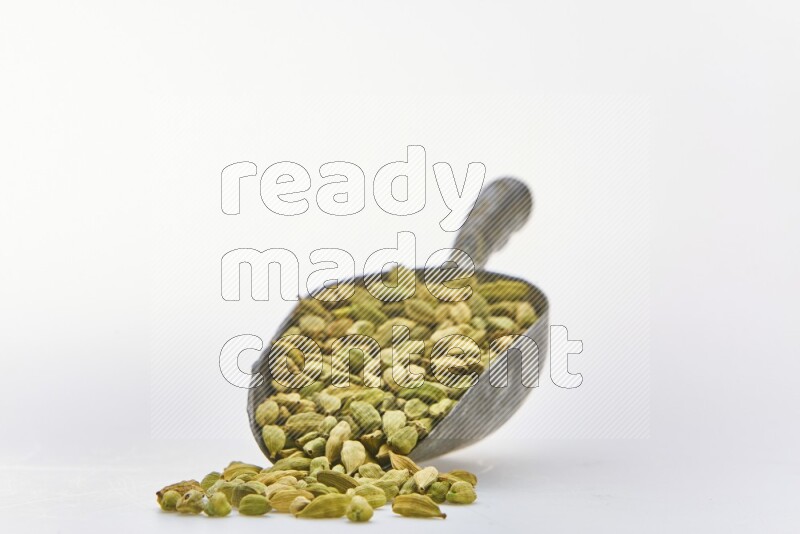 Cardamon in a shovel on white background