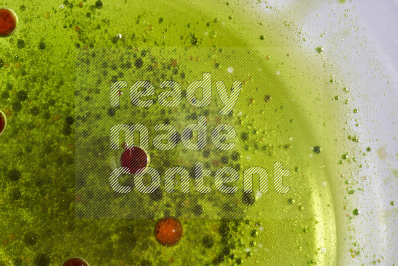 Close-ups of abstract red and green watercolor drops on oil Surface on green background