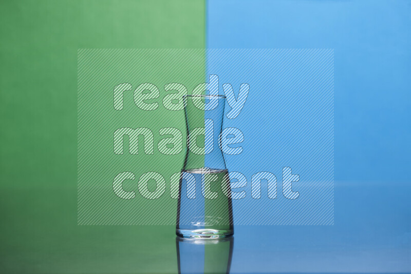 The image features a clear glassware filled with water, set against green and blue background