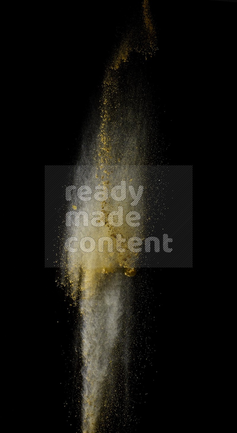A side view of yellow powder explosion on black background