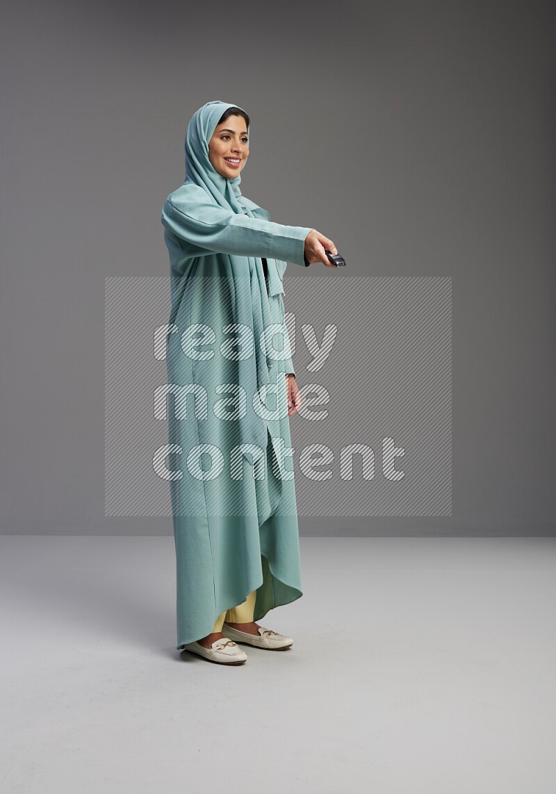 Saudi Woman wearing Abaya standing holding car key on Gray background