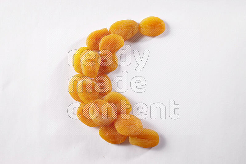 Dried apricots in a crescent shape on white background