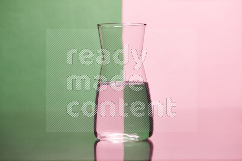 The image features a clear glassware filled with water, set against green and rose background