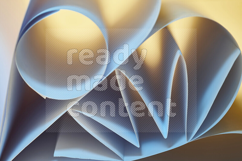 An artistic display of paper folds creating a harmonious blend of geometric shapes, highlighted by soft lighting in blue and warm tones