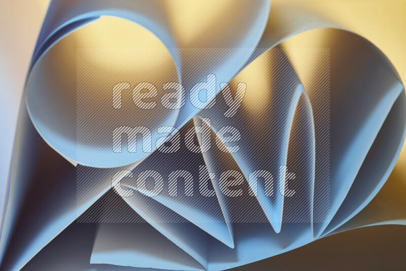 An artistic display of paper folds creating a harmonious blend of geometric shapes, highlighted by soft lighting in blue and warm tones