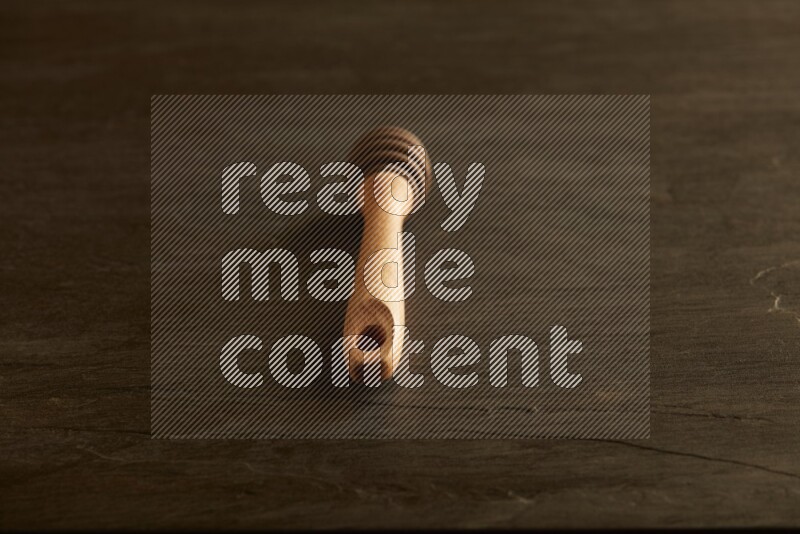 Wooden honey dipper on black slate background