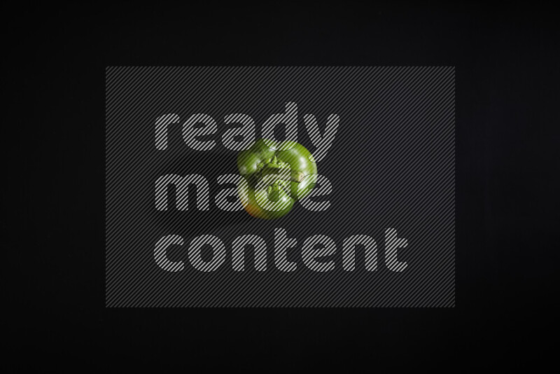 Green bell pepper on black background