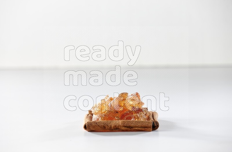 A single square of cinnamon sticks full of Arabic gum on white flooring