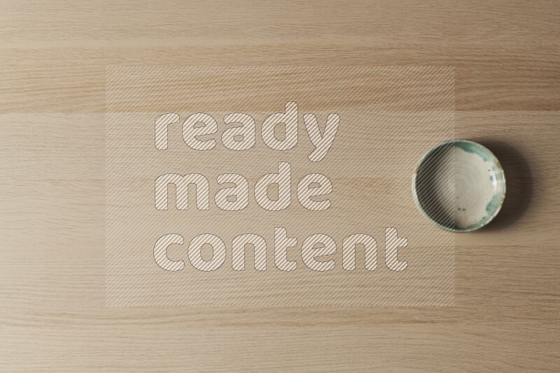 وعاء فخاري متعدد الألوان على خلفية خشبية فاتحة