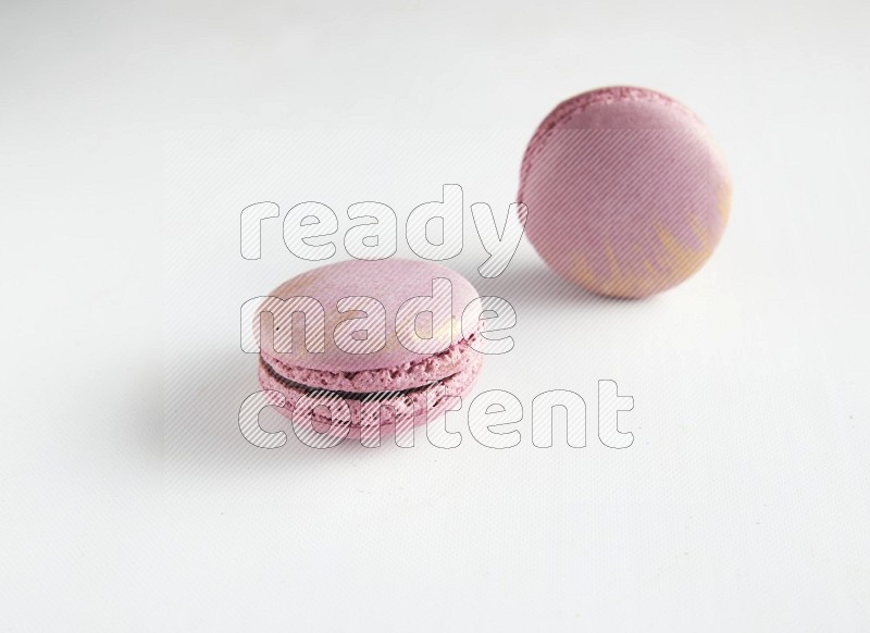 45º Shot of two Purple Strawberry macarons on white background