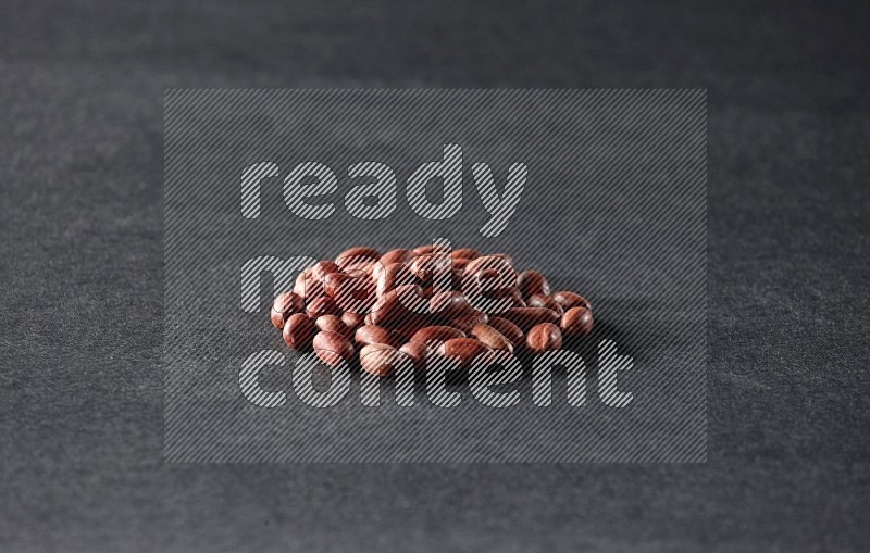 A bunch of red skin peanuts on a black background in different angles