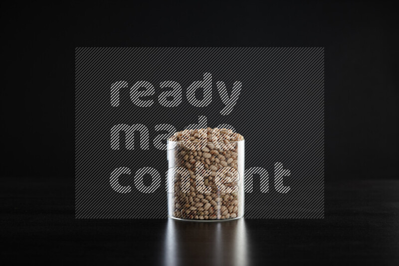 Black-eyed peas in a glass jar on black background