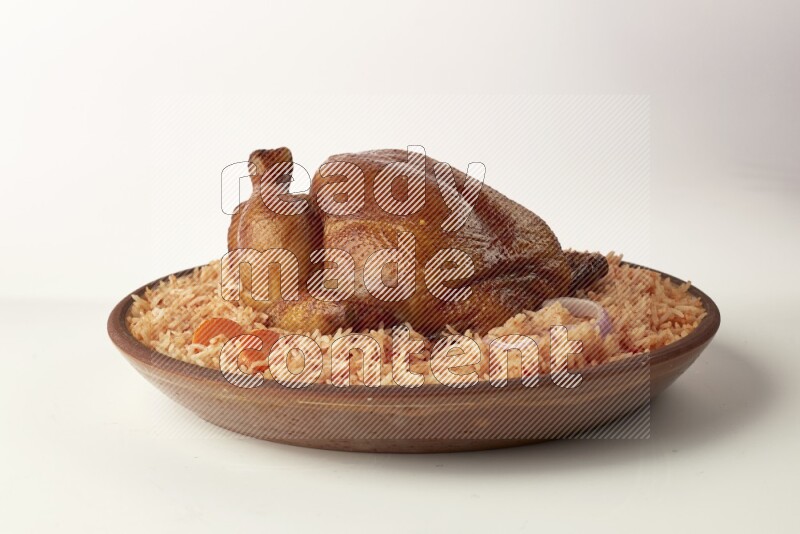 red basmati Rice with whole roasted chicken on a pottery plate direct on white background
