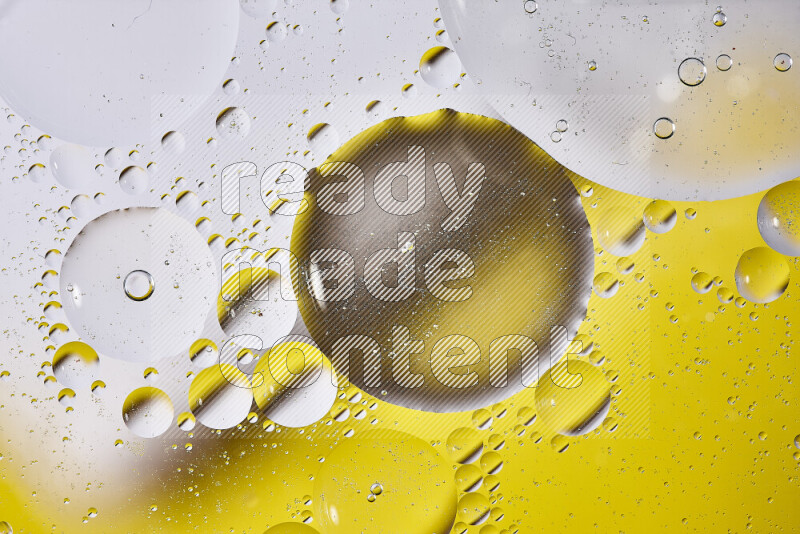 Close-ups of abstract oil bubbles on water surface in shades of white and yellow