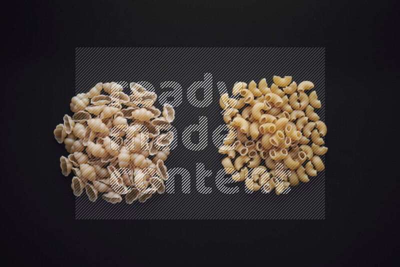Different pasta types in bunches on black background