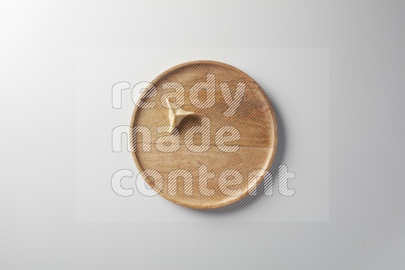 A single Sambosa on a wooden round plate on a white background
