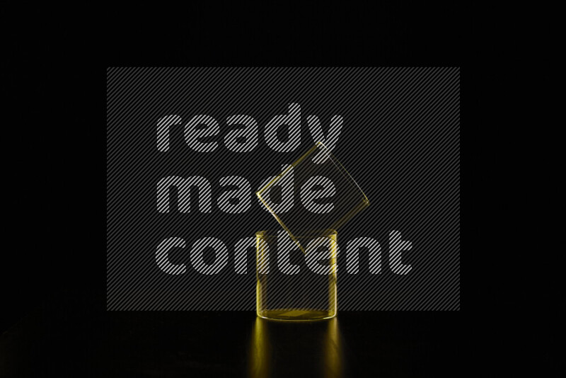 Glassware with rim light in yellow against black background