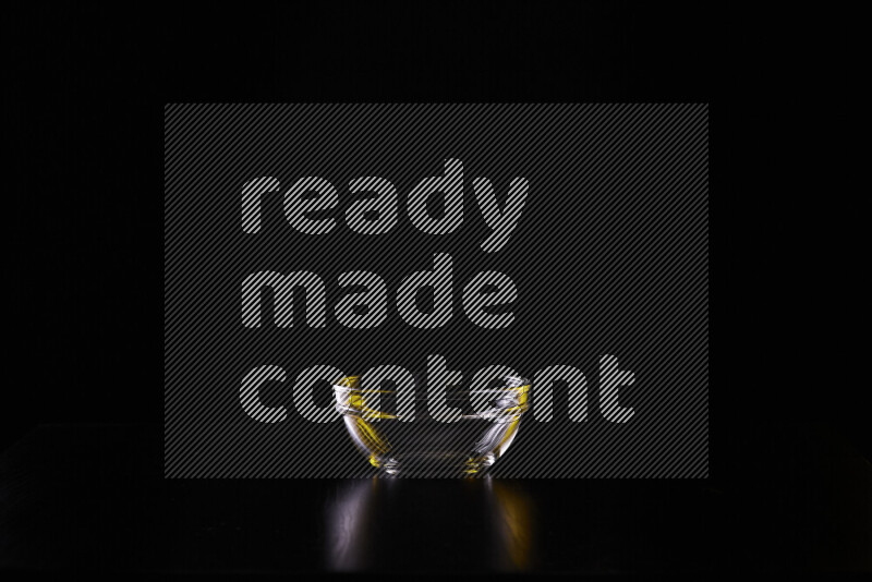 Glassware with rim light in yellow and white against black background