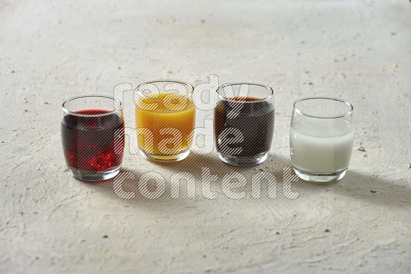 Cold drinks in a glass cup such as water, tamarind, qamar eldin, sobia, milk and hibiscus on textured white background