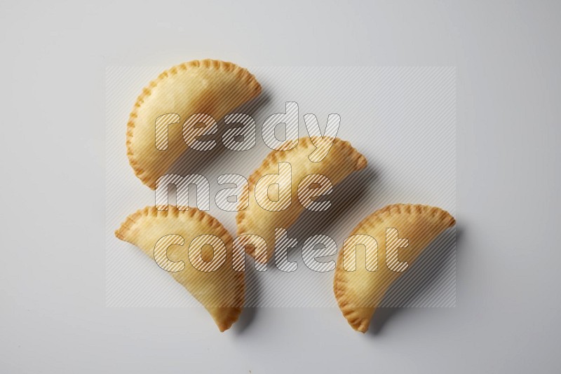 Four fried sambosa from a top angle on a white background