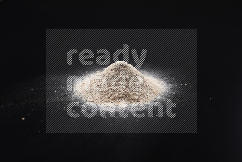 A bunch of onion powder on black background