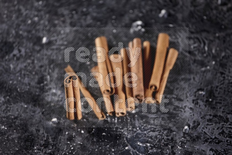 Cinnamon sticks on a textured black background