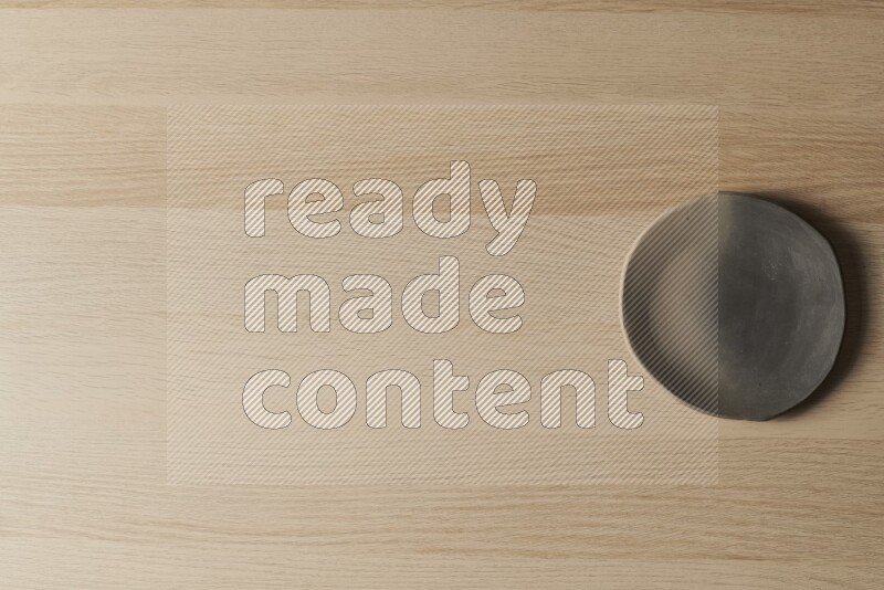 صحن فخاري متعدد الألوان على خلفية خشبية فاتحة