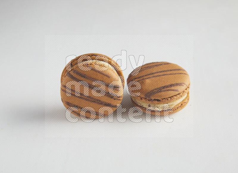 45º Shot of two light brown  Almond Cream macarons on white background