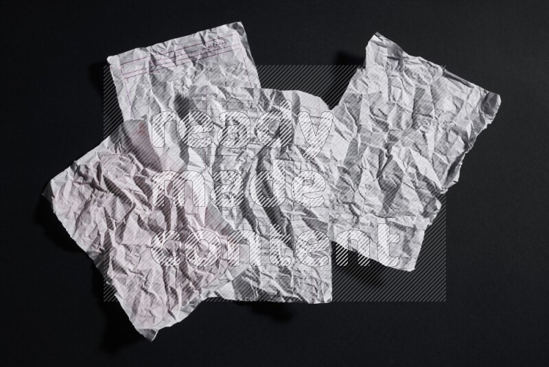 Crumpled notebook sheet on black background
