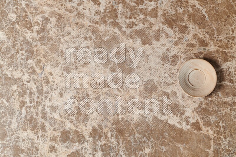 A beige pottery plate on beige marble background