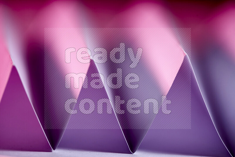 A close-up abstract image showing sharp geometric paper folds in purple gradients