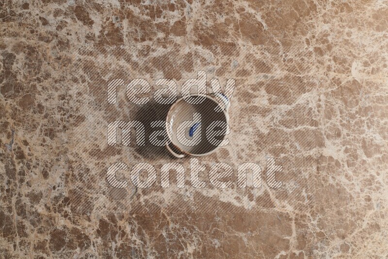 وعاء فخاري متعدد الألوان على خلفية من الرخام البيج