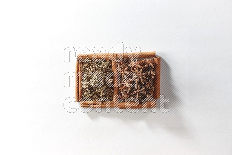 2 squares of cinnamon sticks full of star anise and dried basil on white flooring