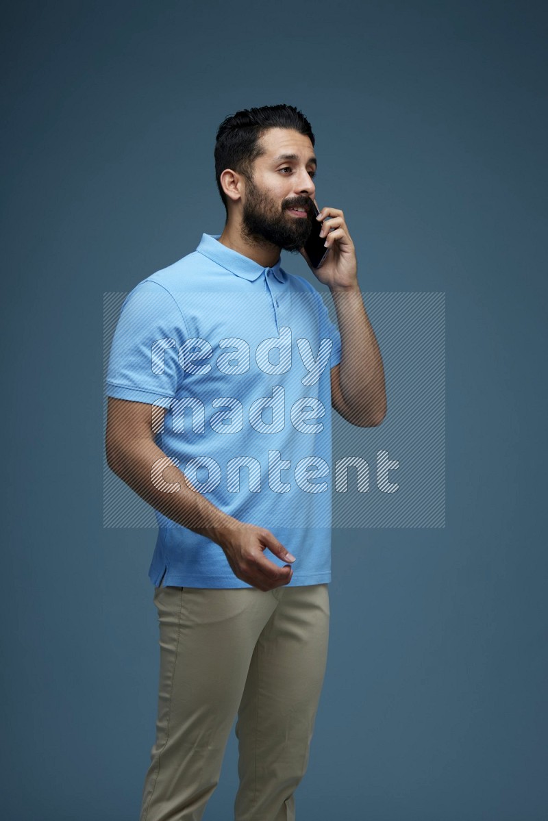 A man having a Call in a blue background wearing a Blue shirt