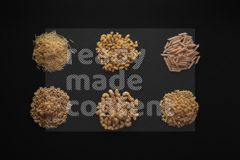Different pasta types in bunches on black background