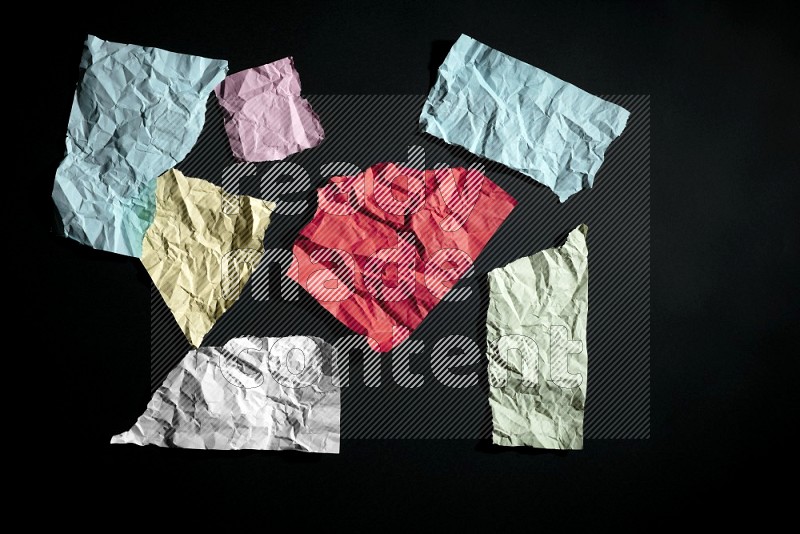 Crumpled multicolored paper on black background