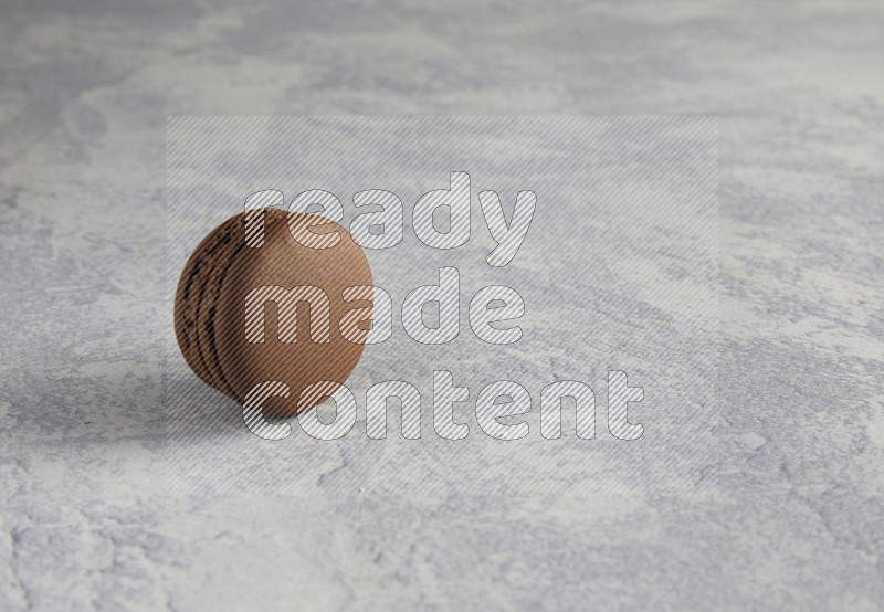 45º Shot of Brown Dark Chocolate macaron on white  marble background