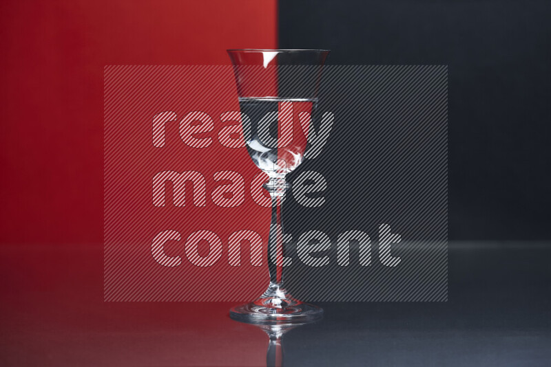 The image features a clear glassware filled with water, set against red and black background