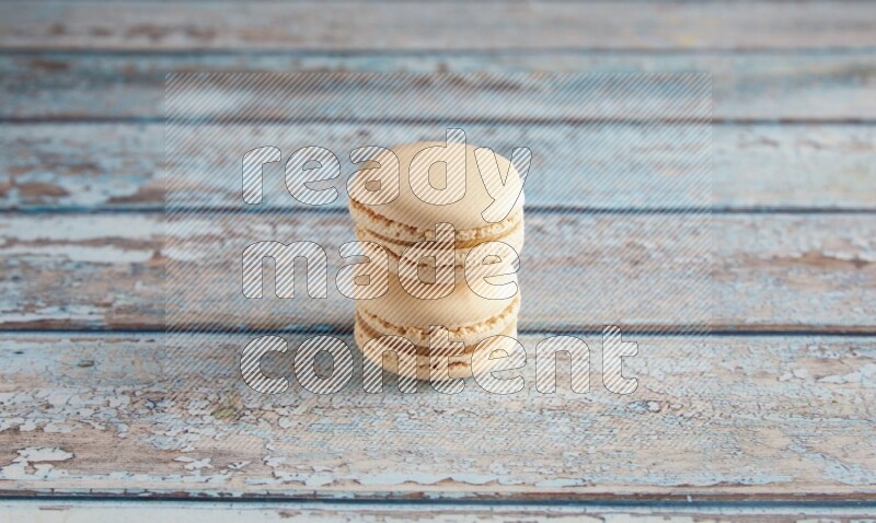 45º Shot of two White Caramel fleur de sel macarons on a light blue wooden background