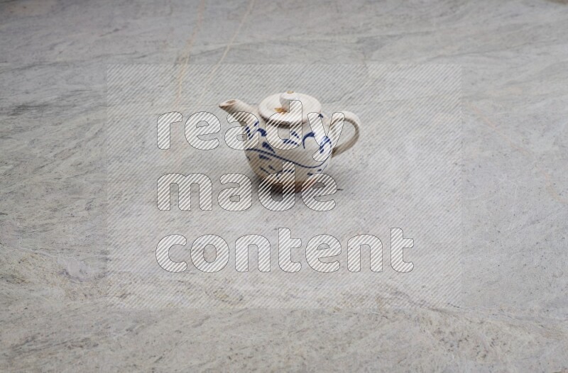 A pottery teapot on grey marble background