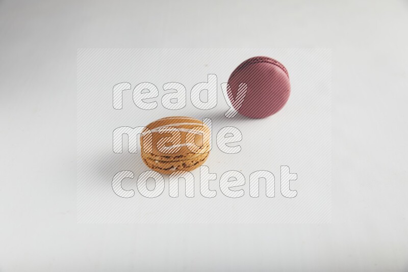 45º Shot of of two assorted Brown Irish Cream, and Red Cherry macarons on white background