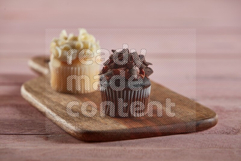 Chocolate mini cupcake topped with chocolate curls on a wooden board