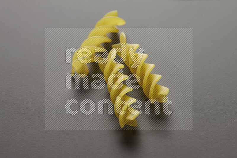 Fusilli pasta on grey background