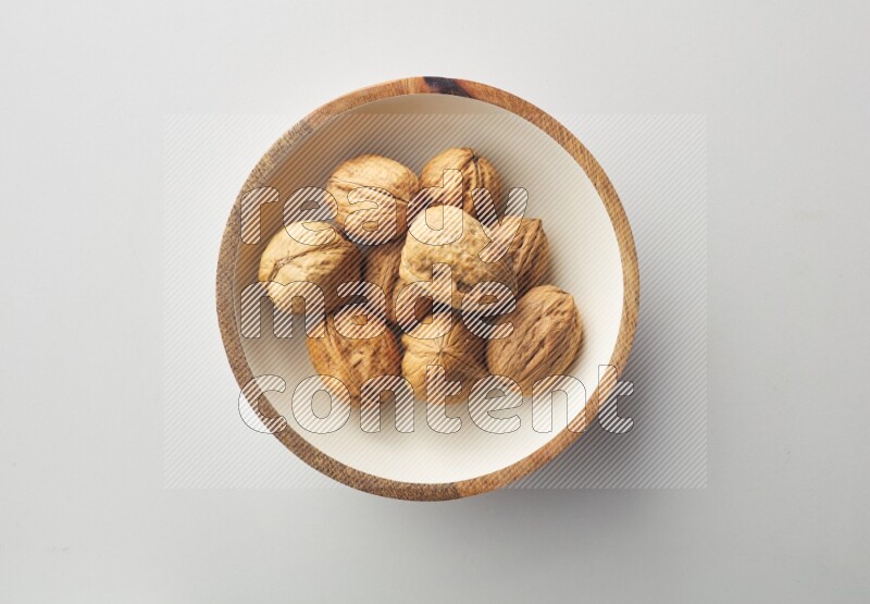 Top-view shot of walnut in a container on white background