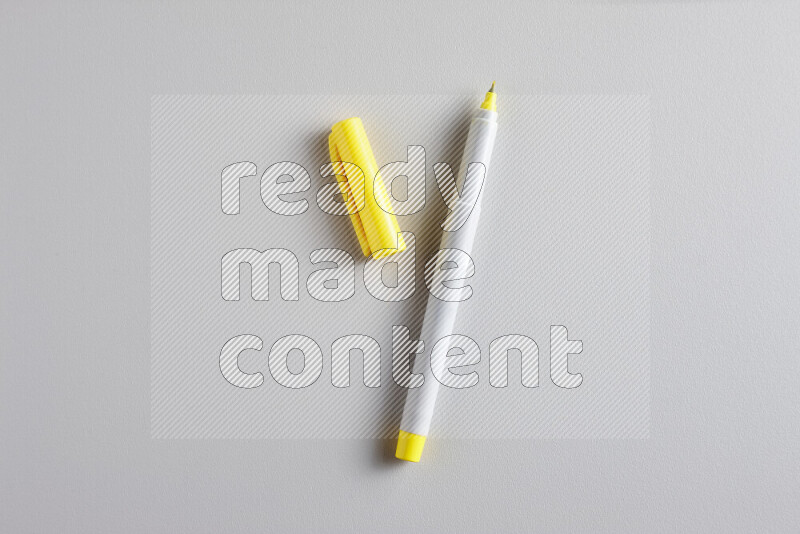A close-up showing an open single coloring pen with a cap on grey background