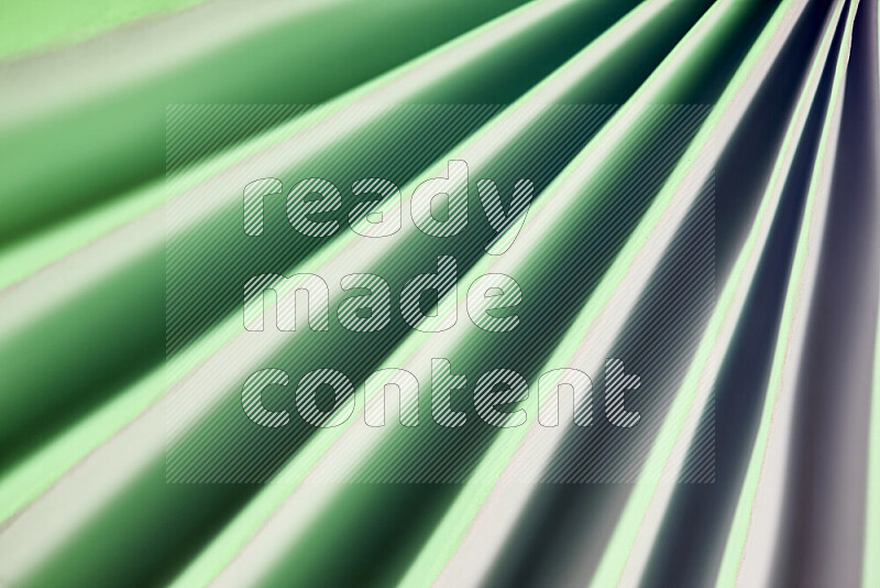 An image presenting an abstract paper pattern of lines in green tones