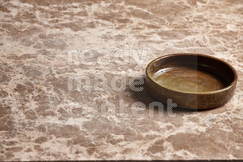 A multicolored pottery oven plate on beige marble background