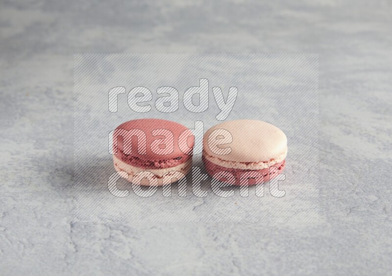 45º Shot of two Pink Litchi Raspberry macarons  on white  marble background
