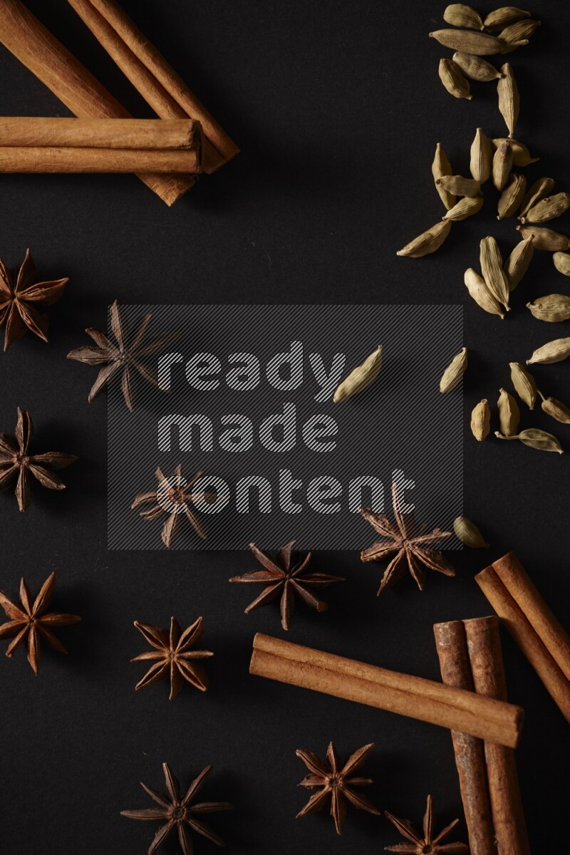 أعواد من القرفة وحبوب الهيل واليانسون النجمي علي خلفية سوداء